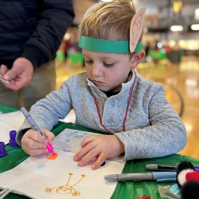 Child participates in crafting during 2024 Elf Academy